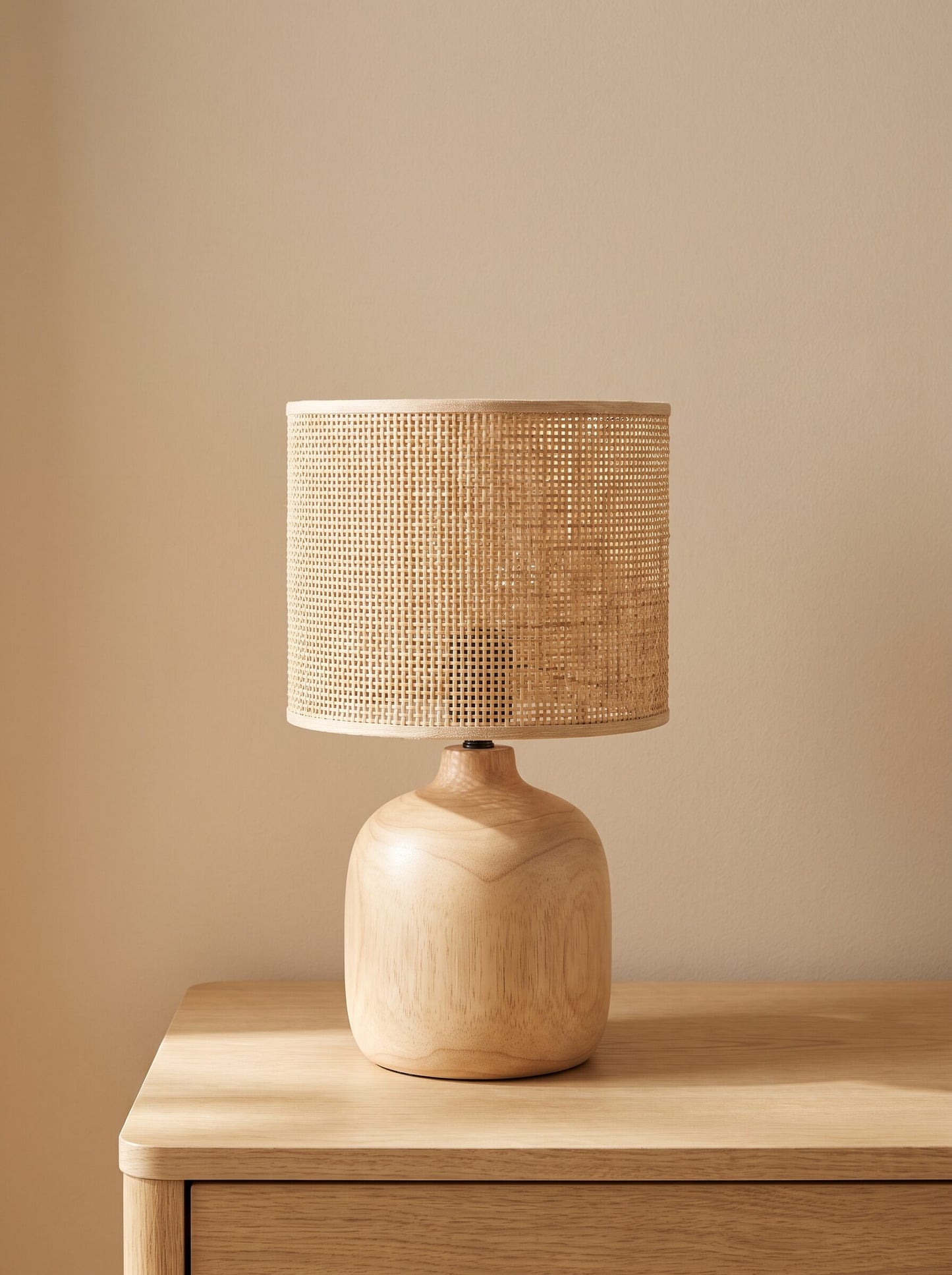 Lámpara de mesa con base de madera y pantalla de ratán tejido, vista frontal