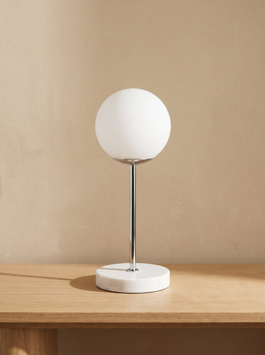 Lámpara de mesa con base de mármol blanco y globo de cristal esmerilado, vista frontal