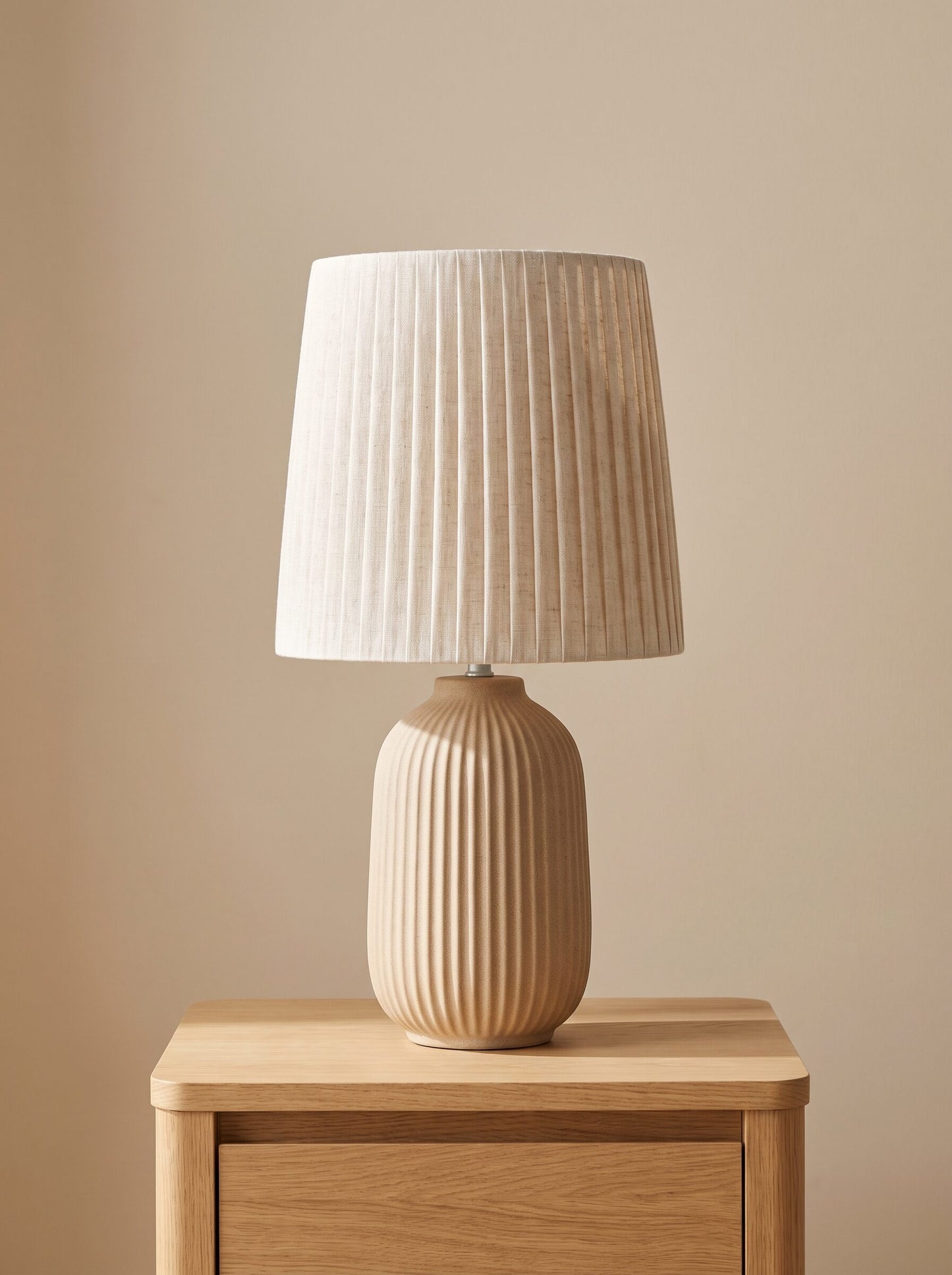 Lámpara de mesita de noche con base de cerámica estriada beige y pantalla de lino, vista frontal