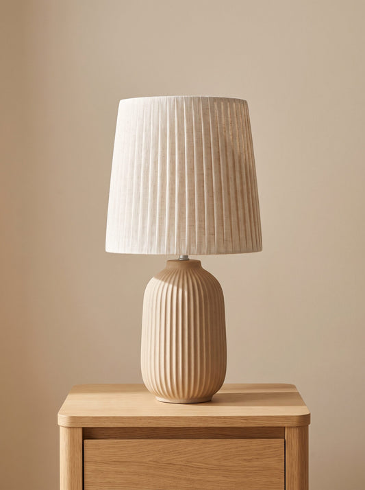 Lámpara de mesita de noche con base de cerámica estriada beige y pantalla de lino, vista frontal